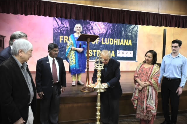 Trustees and guests gathered around the lamp on stage