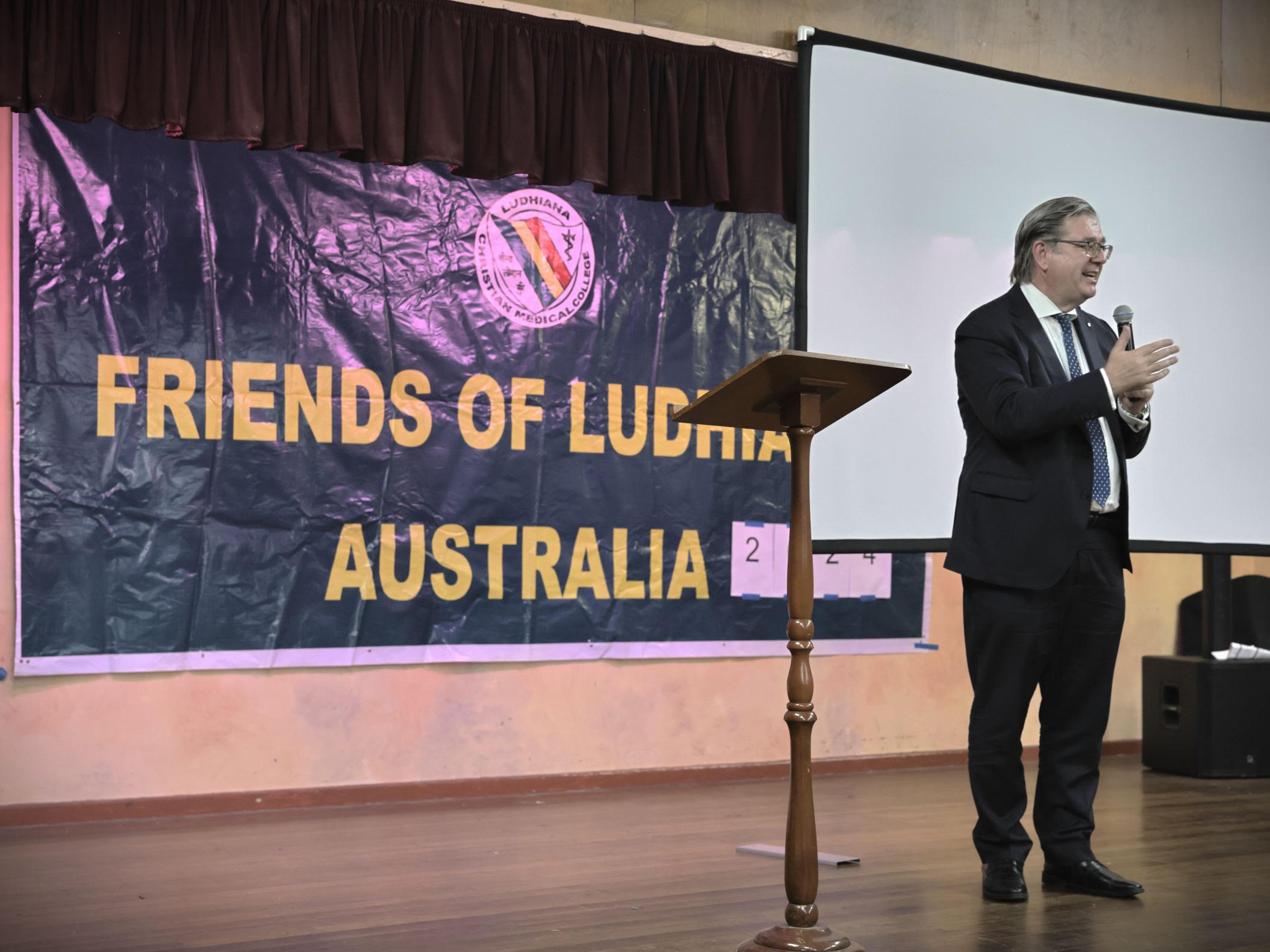 Speaker addressing guests beside the Friends of Ludhiana Australia banner